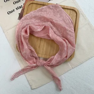 Close-up detail of the pink floral lace triangle scarf, soft linen blend fabric, elegant trim.