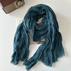 Dark teal crinkled cotton linen scarf detail, vintage fringe style texture close-up shot.