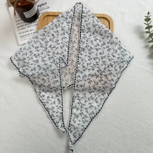 Close-up view of the delicate floral print triangular scarf featuring elegant lace edge.