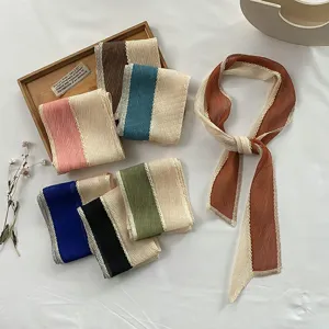 Detailed view of pleated color-block silk scarves for hair and bag accessories styling.