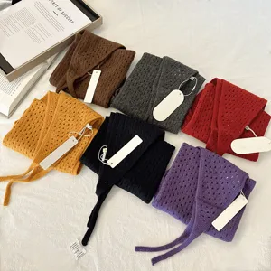 Detail shot of hollow knit triangle scarves in multi colors, showing delicate texture and ties.