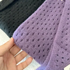 Detailed shot of hollow-out knit triangular scarf texture, premium woolen material close-up.