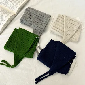 Detailed shot of hollow-out knitted triangular scarves in multi-colors, soft woolen texture.