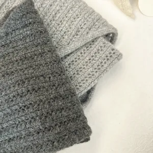Knitted wool shawl detail close up, showing soft corn stitch texture and warm cozy style.