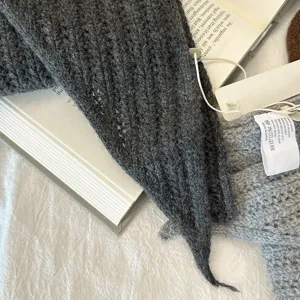 Dark grey 100% wool knitted triangular scarf detail, cozy winter warm shawl texture.