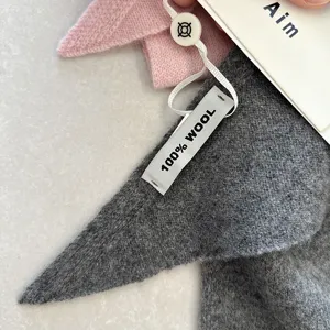 Nahaufnahme des weichen 100% Wolle Dreieckschals zeigt die feine Textur und das Etikett.
