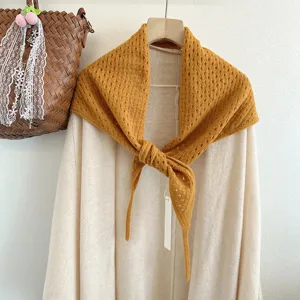 Detailed view of hollow knit wool triangular scarf, stylish solid color design, cozy texture.