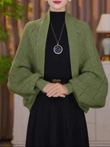 Close-up view of olive green knit cardigan with diamond pattern and batwing sleeves detail.