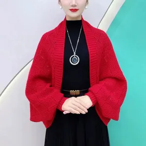 Detail view of the red knitted cardigan featuring diamond pattern texture and cozy sleeves.