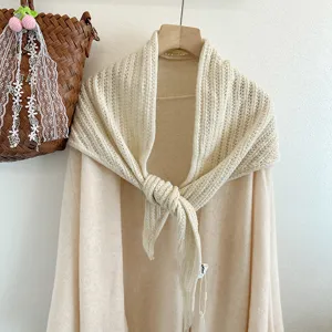 Detail view of the beige wool knitted triangle shawl scarf, cozy and stylish texture.