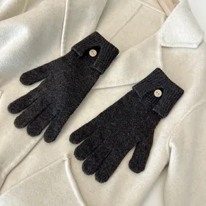 Detailed shot of dark grey knit gloves with button accent, perfect for autumn and winter wear.
