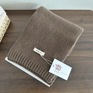 Detailed view of a cozy brown knitted wool scarf, showcasing soft texture and warm winter fabric.