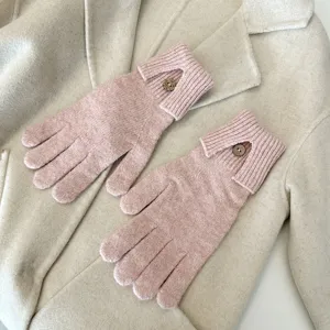 Solid color warm knitted gloves for women with touch screen and single button detail.