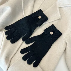 Detailed view of women knit touchscreen gloves with stylish button design in classic black.