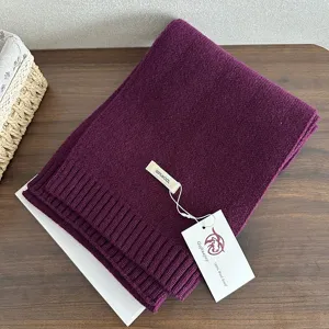 Detail view of a cozy purple 100% wool knitted scarf, winter warm and stylish accessory.