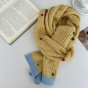 Cozy yellow knit winter scarf with colorful dots and blue hem for women, stylish and warm daily.