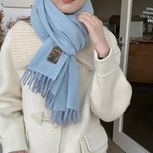 Cozy winter women scarf, soft light blue knit fringe design, stylish warm apparel accessory.