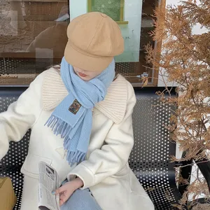 Detailed view of a solid color winter knitted scarf, cozy cashmere-feel tassel design.