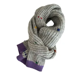 Gray knitted winter scarf with colorful dots and purple ends, soft warm cozy fashion neckwear.
