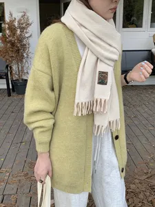 Winter warm imitation cashmere solid color scarf with tassel and knit cardigan outfit.