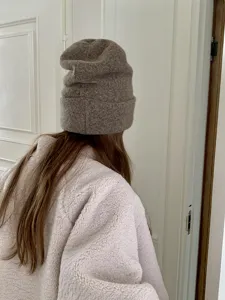 Knit beanie hat detail view, warm wool blend slouchy cap in brown color for women daily wear.