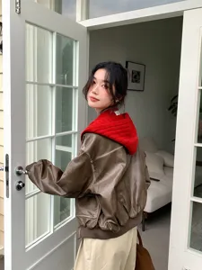 Details of women's brown leather jacket and red knitted balaclava scarf set in lifestyle room.