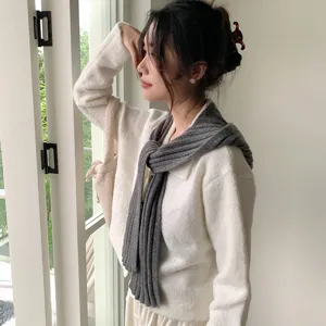 Cozy knit scarf and stylish white top detail shot, perfect autumn winter fashion and warmth.