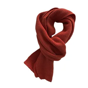 Cozy rust red knitted winter scarf for women and men, warm and soft fashion accessory.