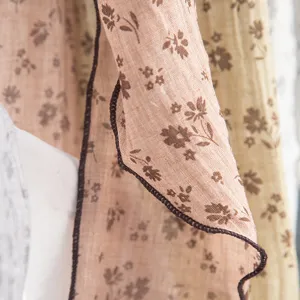 Nahaufnahme eines ländlichen Blumenschals, der weiche Textur und braunen Saum zeigt.