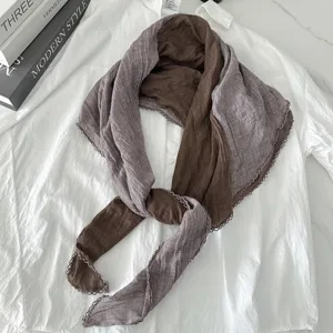 Close-up detail of color-blocked cotton linen scarf with delicate lace trim, stylish spring shawl.