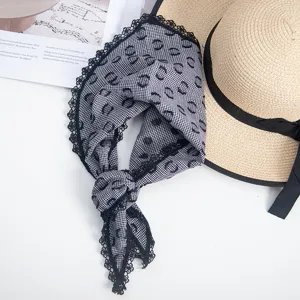 Detail view of retro black and white houndstooth triangle scarf with delicate black lace trim.