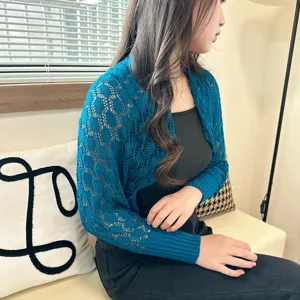 Detailansicht blauer Strick Bolero, gemütlicher Innenbereich, stilvoller kurzer Cardigan Look.