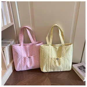 Vista dettagliata della borsa tote in tessuto a pois con tasca con coulisse in stile lifestyle.