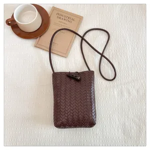 Stylish brown woven PU leather phone crossbody bag with chic horn toggle closure detail.