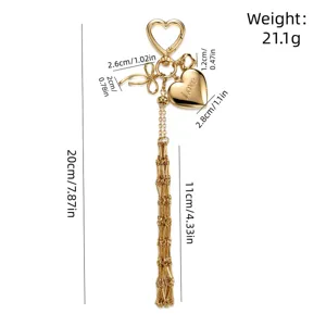 Gold metal heart keychain with long tassel and love engraved pendant accessory for women handbag.