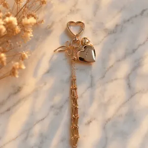 Golden metal heart bag charm keychain with bow and tassel pendant for stylish women bags.