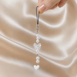 Pearl bow phone strap detail shot showing delicate beads, translucent bow and white heart.