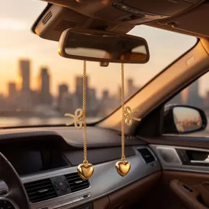 Detailed view of gold metal rearview mirror hanging ornament with rhinestone bows and hearts.