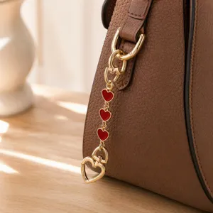 Chic metal bag chain detail with red enamel heart pendants, stylish purse charm and keyring.