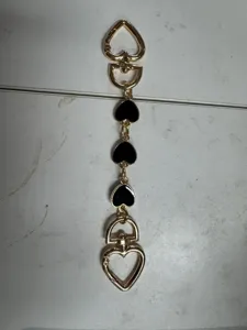Gold metal heart bag charm with black enamel, stylish keychain strap accessory for women.