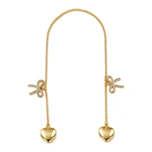 Gold metal chain rearview mirror hanging ornament with rhinestone bow and heart pendants.