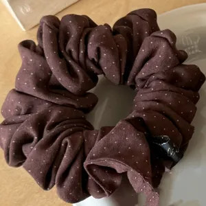 Brown polka dot scrunchie detail view, soft brushed fabric texture for gentle hair styling.