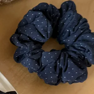 Close-up detail of retro polka dot washed fabric scrunchie, soft hair tie for daily wear.