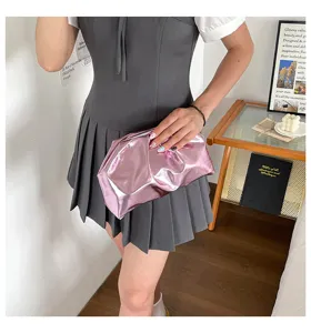 Détail de pochette nuage en PU plissé métallique rose, accessoire de soirée texture douce.
