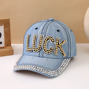 Berretto da baseball in denim azzurro da donna con lettere LUCK in strass e visiera curva.
