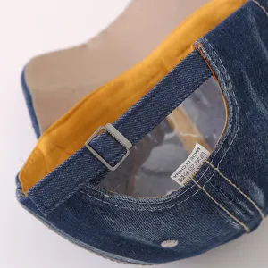 Vista dettagliata del cappellino da baseball in denim casual con fibbia regolabile ed etichetta.