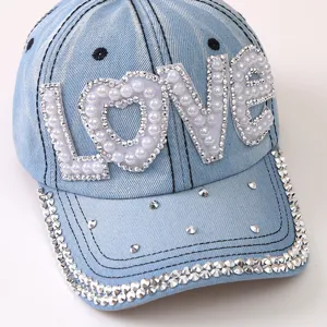Vista dettagliata del berretto da baseball in denim azzurro con perle strass LOVE.