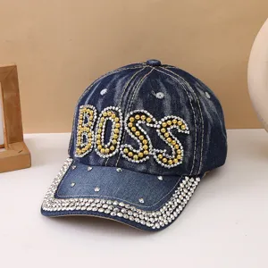 Primo piano del berretto da baseball in denim con strass e lettere BOSS sul davanti.