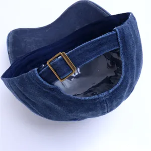 Gedetailleerd overzicht van de blauwe denim pet met verstelbare metalen gesp en binnenvoering.