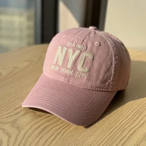 Close-up detail of the pink soft top baseball cap featuring delicate embroidered NYC letters.